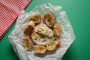 Baked camembert with toasts , rosemary on white cooking paper