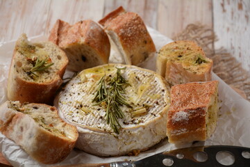 Baked camembert with toasts , rosemary on white cooking paper