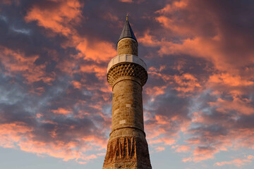 historical Broken Minaret of oldtown, Antalya, Turkey with sky and red clouds.