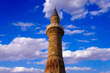 historical minaret with blue sky and white clouds.