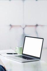 Mockup blank screen laptop computer with pen and notebook on white top table, vertical view. - obrazy, fototapety, plakaty