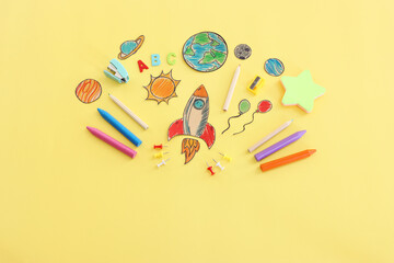 Back to school concept. Top view image of space ship, planets and student stationery over pastel yellow background - obrazy, fototapety, plakaty