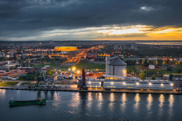 Fototapeta na wymiar The port scenery of the Martwa Wisla and illuminated stadium in Gdansk at sunset. Poland.