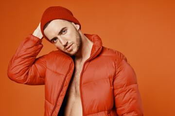 fashionable man in red jacket nude body studio orange background