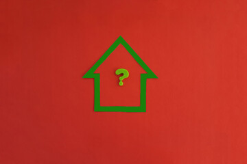 Fototapeta na wymiar A house, a green question mark on a red background. The concept of determining the value of real estate. Business, sale of housing.
