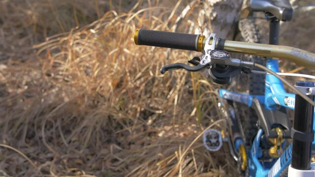 The rider's hand takes the helmet from the bicycle handlebar