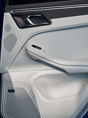 Control panel with chrome handle on the back car door white genuine leather in a new car with arm rest.