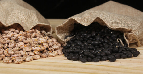 Dried Pinto Beans and Black Beans in Burlap Bag on Wooden Background