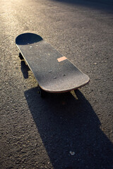 Skate on road illuminated by evening sun