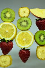 Fototapeta na wymiar Different fruits on light background. Banana, strawberry, kiwi, lemon and apple