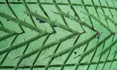 Photograph of an old car tire with an arrow pattern painted in green