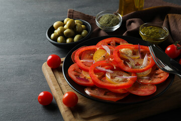 Concept of tasty food with tomato carpaccio on dark table