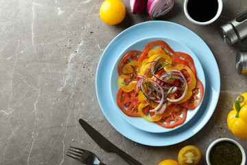 Concept of tasty food with tomato carpaccio on gray textured table