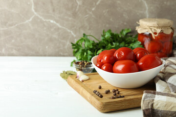 Concept of pickled vegetables with tomatoes on white wooden table