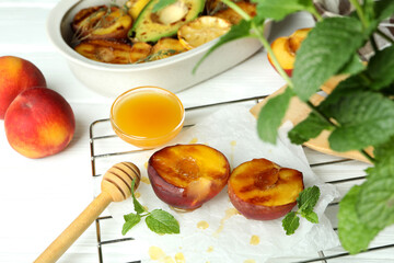 Concept of tasty food with grilled peach on white wooden table