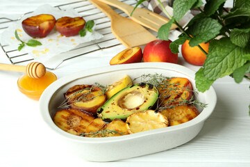 Concept of tasty food with grilled peach on white wooden table