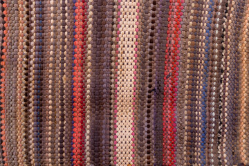 Rough cloth texture. Old fabric design with vertical stripes was made in a traditional knitting style.