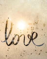 winter glass with sun, inscription love on frozen glass, Valentine's Day card