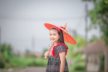 Close-up background view of a blurred Asian girl running or teasing in the street in front of the house, doing activities together outside the classroom during the holidays.