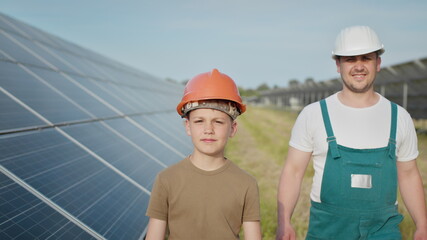 Engineer father is explaining to his little son an operation and performance of photovoltaic solar...