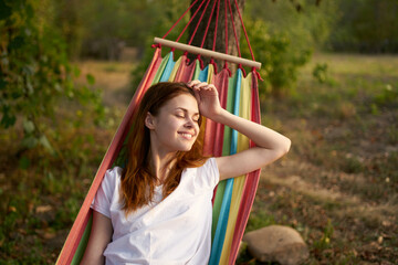 cheerful woman lies in a hammock in nature sun rest