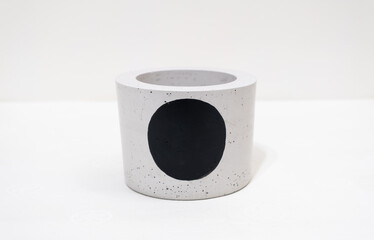 Colorful, handmade cactus pot on a white background with fine holes in the texture and painted black dot