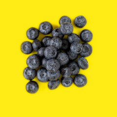 Delicious fresh organic blueberries on bright yellow background, top view, view from above