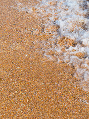 Marine vertical background: close-up of a wave on the beach