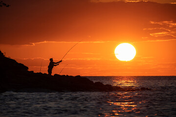 Fototapeta na wymiar A man at sunset fishing