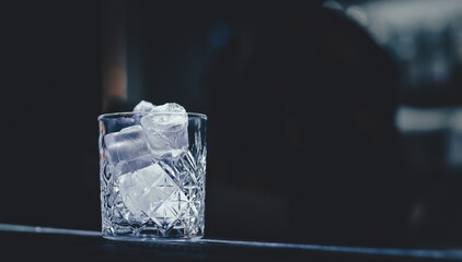 Ice cube in an empty glass on a bar counterin bar or pub