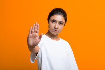 Portrait of young adult indian woman with stop gesture hand palm