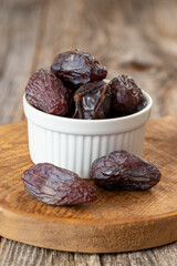 Date fruit in a plate. Date fruit on wood background. Organic and fresh nuts. close up