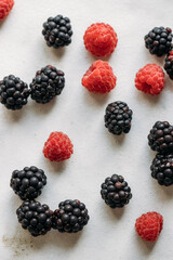 Berry background. Blackberries and raspberries on marble background