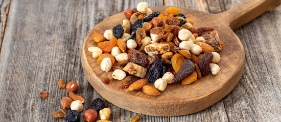 Mixed nuts on wood floor. Organic and fresh nuts. Wooden spoon on top of nuts. Copy space