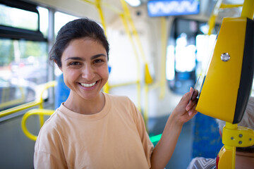 Indian Woman paying conctactless with card for public transport bus or tram
