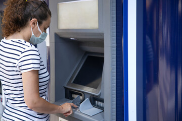 Naklejka na ściany i meble Young woman taking money from ATM