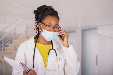 Focused afro american female doctor listening to her phone