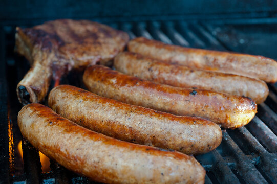 Sausages and meat chop on bbq, close up selective focus