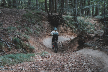 medium wide shot of female mountainbiker cornering on flow trail