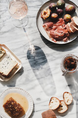 Rose wine and snacks over marble background, copy space