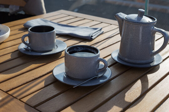 Gray ceramic teapot and pair of cups with five o'clock tea.
