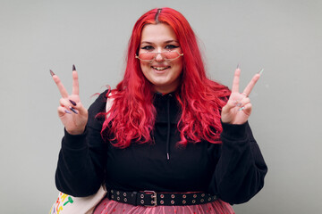 Plus size overweight fat body positive lgbtq woman with red hair and pink glasses.