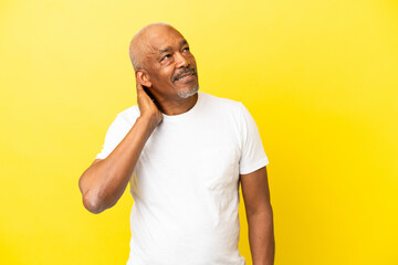 Cuban Senior isolated on yellow background thinking an idea