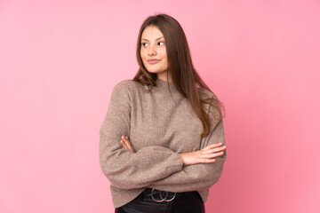 Fototapeta premium Teenager caucasian girl isolated on pink background keeping the arms crossed