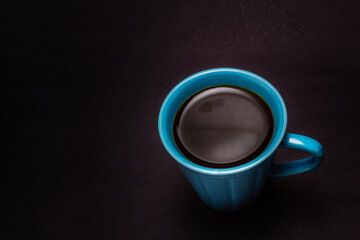 Uma xícara azul com café.