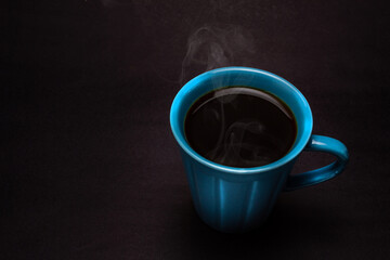 Uma xícara azul com café quente, saindo vapor.
