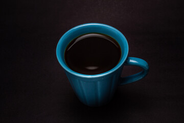 Uma xícara azul com café.