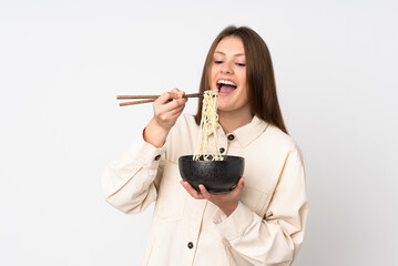 Teenager caucasian girl isolated on white background holding a bowl of noodles with chopsticks and eating it