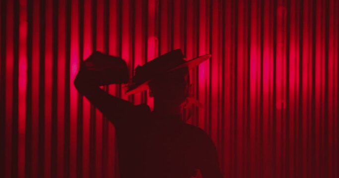 Beautiful hat dressed girl dancing latin dance . Professional female dancer dancing flamenco , rumba or salsa on red background with lines . Spanish dance movements . Shot ARRI ALEXA Cinema Camera .