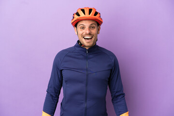 Young Brazilian cyclist man isolated on purple background with surprise facial expression